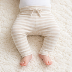 Baby trägt die gestreifte Little Dutch Babyhose Stripe Sand/White